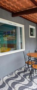 a patio with a table and chairs and a window at Flats KENAI in Abraão