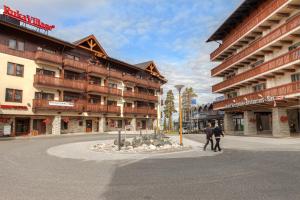 two people walking down a street in front of a building at Hippu Apartment in Ruka