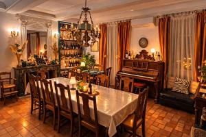 a dining room with a table and a piano at Les 2 Drôles d'Oiseaux in Luc-sur-Orbieu