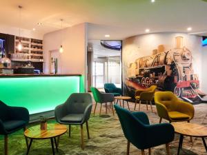 a waiting room with chairs and a green screen at Mercure Rennes Centre Gare in Rennes