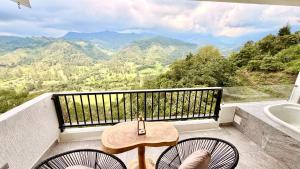 a balcony with a table and two chairs and a tub at Hotel El Mirador del Cocora in Salento