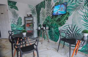 two tables and chairs in a room with a mural at Villa Maraf - Adults Only Boutique Hotel in Cancún