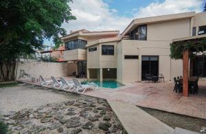 a house with a swimming pool and lounge chairs at Villa Maraf - Adults Only Boutique Hotel in Cancún