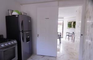 a kitchen with a refrigerator and a table with chairs at Villa Maraf - Adults Only Boutique Hotel in Cancún