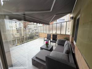 a patio with a couch and chairs on a balcony at Rheinperle Wesel in Wesel