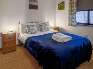 a bedroom with a bed with a blue blanket on it at Capstan Cottage in Whitby +4 photos