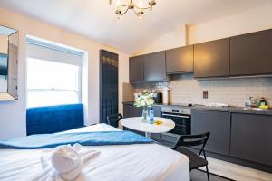 a room with a bed and a table and a kitchen at Superb Studio With Marina Views- WiFi Included in Dublin