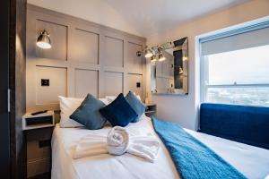 a bedroom with a bed with blue pillows and a window at Superb Studio With Marina Views- WiFi Included in Dublin