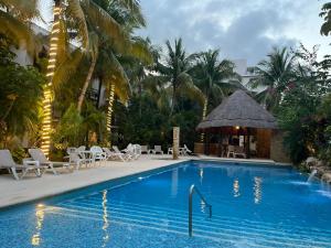 a swimming pool with chairs and a gazebo at Amazing 2 bedroom condo steps from the beach! in Playa del Carmen