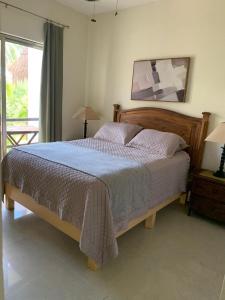 a bedroom with a bed with a blue comforter at Amazing 2 bedroom condo steps from the beach! in Playa del Carmen