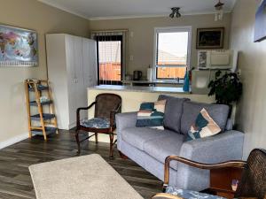 a living room with a couch and a kitchen at Almost Country in Taupo