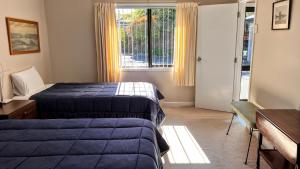 a hotel room with two beds and a window at Almost Country in Taupo