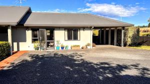 a white house with a driveway in front of it at Almost Country in Taupo