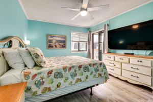 a bedroom with a bed and a dresser with a television at Ocean-View Balcony! Myrtle Beach 3rd-Floor Retreat in Myrtle Beach