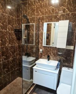 a bathroom with a sink and a mirror and a toilet at The Velvet Stay in Tbilisi City