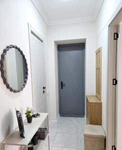 a hallway with a blue door and a mirror at The Velvet Stay in Tbilisi City