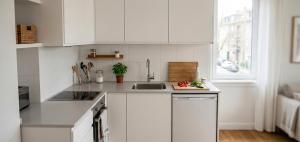 a kitchen with white cabinets and a sink at pınar apart hotel in Kapuluören