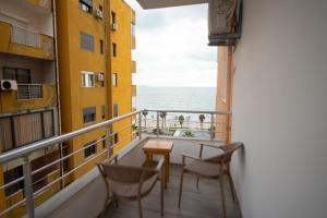 a balcony with a table and chairs and the ocean at Asinara Guatanamo Belmarsh in Durrës