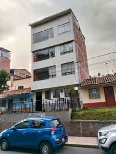 a blue car parked in front of a building at Killitas home&apart in Cusco