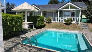 a swimming pool in front of a house at La Posada del Camino in Dina Huapi