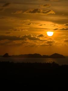a sunset over a body of water at Halimah Guesthouse in Putatan