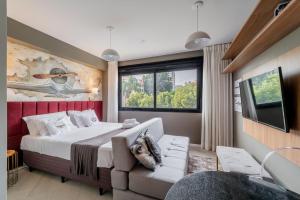 a bedroom with a large bed and a couch at Lucas by Yoo por LikeHome in Auxiliadora