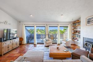 a living room with a couch and a tv at Sunset Serenade in Truro +20 photos