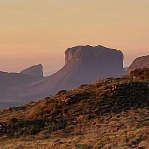 a mountain sitting on top of a hill at Casa Azul Marichi Hospedagem in Vale do Capao +4 photos