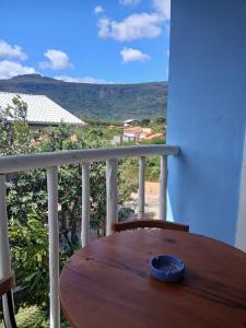 a wooden table on a balcony with a view at Casa Azul Marichi Hospedagem in Vale do Capao