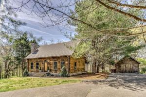 a log cabin house with a driveway and trees at Luxury Lakefront Cabin in Castalian Springs