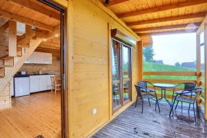 a wooden deck with a table and chairs on it at DOMKI u WILKA - Solina Centrum in Solina
