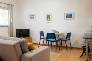a living room with a couch and a table with chairs at Apartamentos do Triângulo in Velas