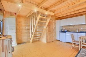 a log cabin with a wooden staircase in a kitchen at DOMKI u WILKA - Solina Centrum in Solina +3 photos
