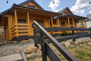 a log cabin with a fence in front of it at DOMKI u WILKA - Solina Centrum in Solina