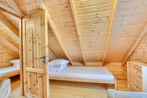 a wooden room with a bed in a sauna at DOMKI u WILKA - Solina Centrum in Solina