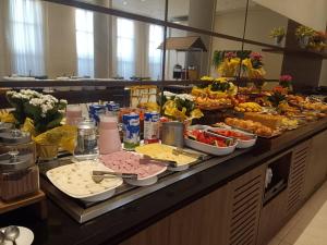 a buffet line with many different types of food at Tulip Inn Sete Lagoas in Sete Lagoas +30 photos