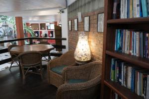 a library with chairs and a table and a lamp at Pousada Estalagem do Porto in Arraial do Cabo