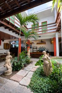 a courtyard with statues in front of a building at Pousada Estalagem do Porto in Arraial do Cabo