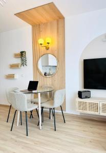 a dining room with a table and chairs and a mirror at Sweet Home - Cocon élégant climatisé, piscine été, balcon & parking privé in Chambéry