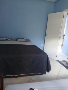 a bedroom with a bed with a black sheet at Casa Azul Marichi Hospedagem in Vale do Capao