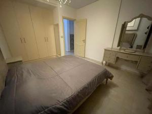 a bedroom with a bed and a mirror and a dresser at Hsan Bouslimi in Ez Zahra +2 photos