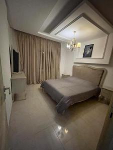 a bedroom with a bed and a television in it at Hsan Bouslimi in Ez Zahra