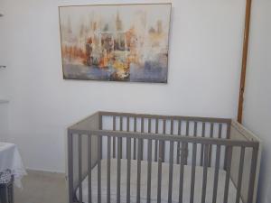 a painting hanging above a crib in a room at Hsan Bouslimi in Ez Zahra