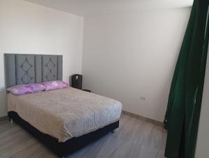 a bedroom with a bed with pink pillows on it at HOTEL CHOQOLAqA RESTAURANT in Cabanaconde