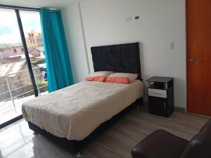 a bedroom with a bed and a large window at HOTEL CHOQOLAqA RESTAURANT in Cabanaconde +2 photos