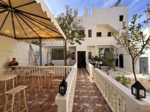an outdoor patio with tables and chairs and an umbrella at Casa Bianca in Marrakesh
