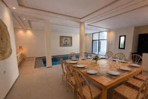 a dining room with a large wooden table and chairs at Casa Bianca in Marrakesh