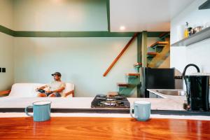 a man sitting on a couch in a living room at Stylish Tiny Home with Sea View and Bathtub in Alto del Espino Prieto