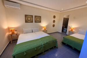 a bedroom with two beds and two lamps on the wall at Casa Bianca in Marrakesh