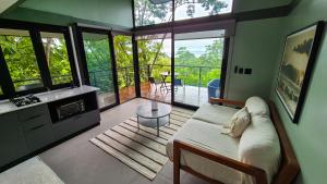 a living room with a couch and a table at Stylish Tiny Home with Sea View and Bathtub in Alto del Espino Prieto